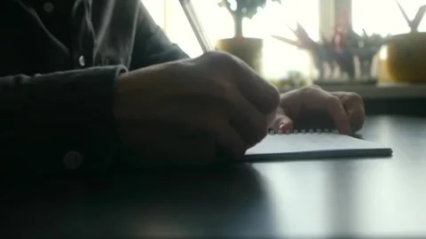 Person's hands writing notes in a notebook with a pen Stock Footage 337892340