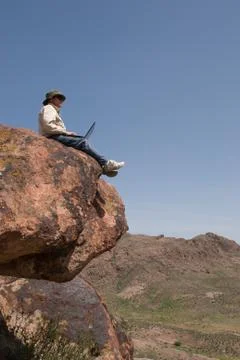 Persons with laptop on stone Stock Photos