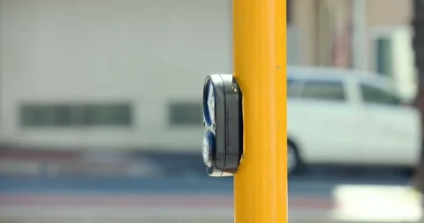 Person's left arm in maroon sleeve pressing walk button on bright yellow pole, Stock Footage 344331217