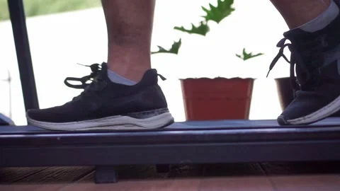 Person's legs jogging on treadmill close up, athletic shoes in motion, cardio Stock Footage 344431857