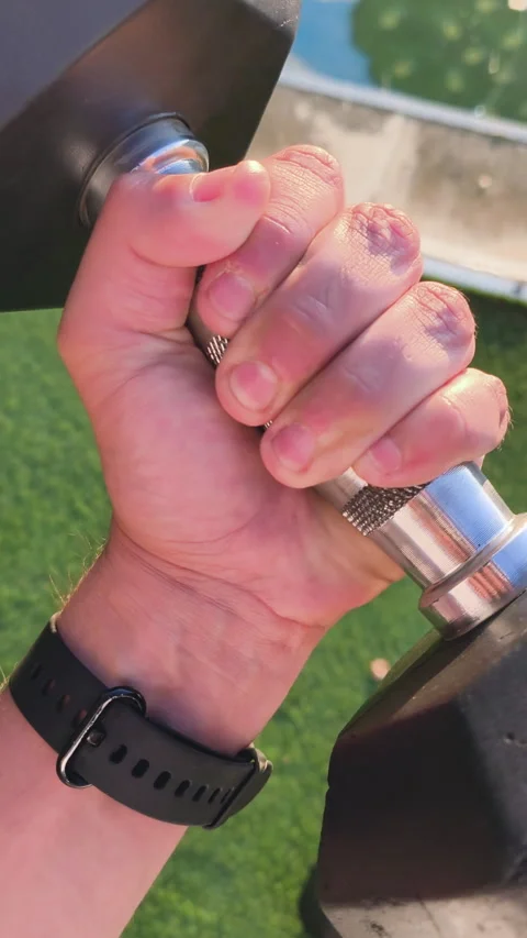 Person's point of view lifting a heavy black dumbbell for bicep curl exercise Stock Footage 339559105