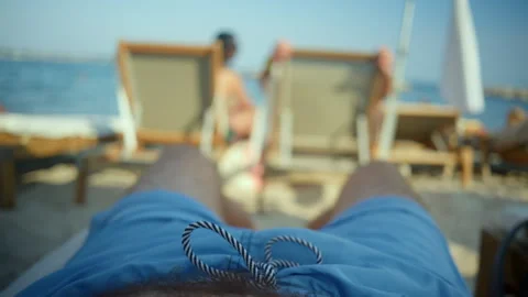 Person's POV lying on a beach chair, wearing blue shorts, enjoying the sun and Video stock 343200019