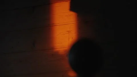 Person's shadow moving through sunset light beam Stock Footage 341294786