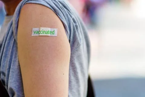 A person's shoulder after vaccination. The patch with the inscription is vacc Foto stock