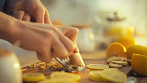A persons skilled hands gently grate a raw brown ginger root unleashing its Stock Footage 336570747