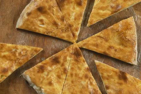 Persons take pieces of baked homemade cheese pie on wooden background. Bulgar Stock Photos