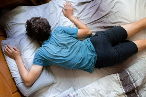 Person's wrong position during the sleep in bed, bad postures Stock Photos