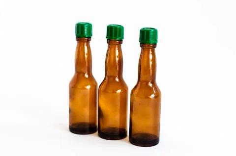 Perspective close-up shoot of three small alcohol bottles brown colored Stock Photos