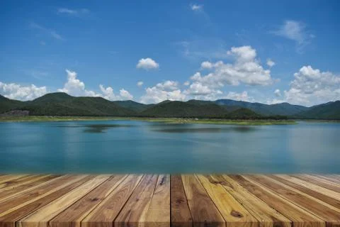 Perspective empty wood table on top over dam and mountain with blue sky in ba Stock Photos