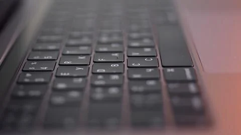 Perspective of a modern computer or laptop black keyboard on pink background Stock Photos