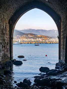 Perspective of the old shipyard Tersane through stone arches in Turkish Ala.. Stock Photos