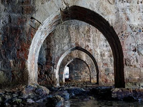Perspective of the old shipyard Tersane through stone arches in Turkish Alany Stock Photos
