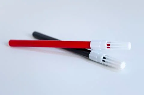 Perspective open shoot of crossed red and black magic marker on white surface Foto stock
