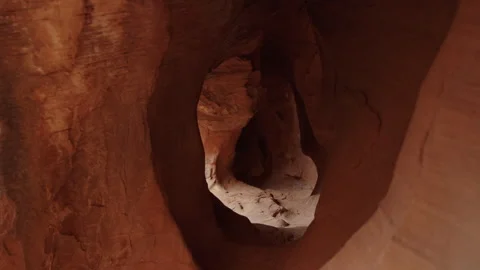Perspective of passing through cave wall holes in slot canyon Escalante Stock Footage 248571734