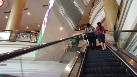 Perspective of person on a moving escalator going up inside a shopping mall. Stock Footage 105401564