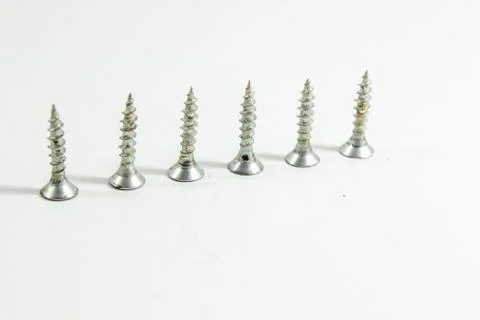 Perspective shoot of diagonal positioned multiple screws on white background Stock Photos
