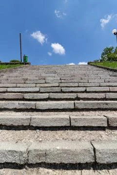 Perspective: staircase with stone steps from bottom to top on a sunny day Foto stock