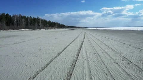 Perspective of tyre tracks on sandy beach Stock Footage 108306601