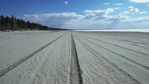 Perspective of tyre tracks on sandy beach Stock Footage 108307126