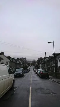 Perspective view down a quiet residential street in Keswick with moody Cumbrian Stock Photos