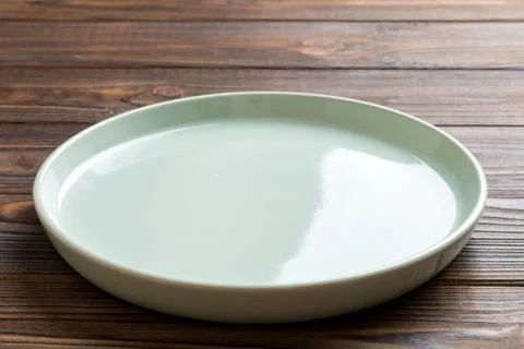 Perspective view of empty blue plate on wooden background. Empty space for .. Stock Photos