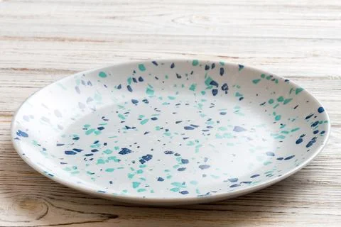 Perspective view of empty colorful plate on cement background. Empty space fo Stock Photos
