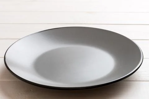 Perspective view of empty grey plate on cement background. Empty space for .. Stock Photos