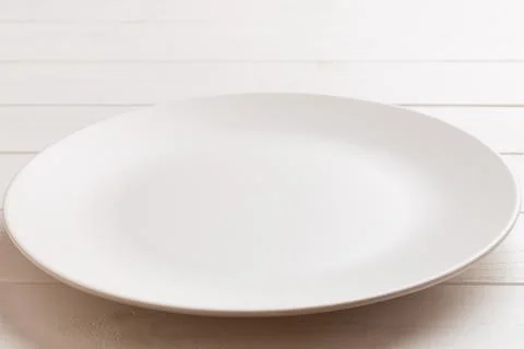 Perspective view of empty light plate on wooden background. Empty space for.. Stock Photos