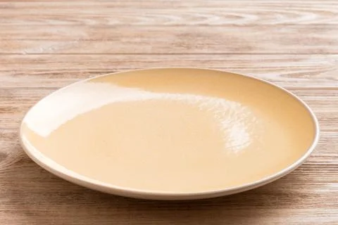 Perspective view of empty orange plate on wooden background. Empty space fo.. Stock Photos