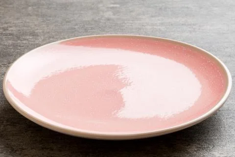 Perspective view of empty pink plate on cement background. Empty space for .. Stock Photos