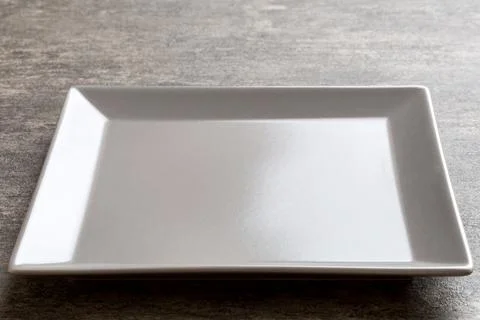 Perspective view of empty square plate on cement background. Empty space fo.. Stock Photos