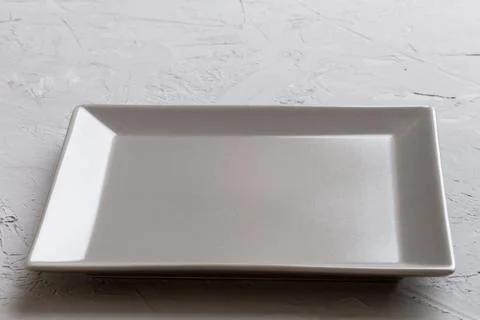 Perspective view of empty square plate on cement background. Empty space fo.. Stock Photos