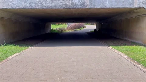 Perspective view from inside a concrete pedestrian tunnel with light at the end Stock Footage 320486177