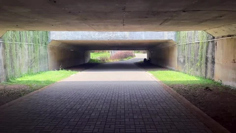 Perspective view from inside a concrete pedestrian tunnel with light at the end Stock Footage 320487907