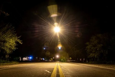 Perspective view of lane lines of an old asphalt road in a dark creepy night Stock Photos