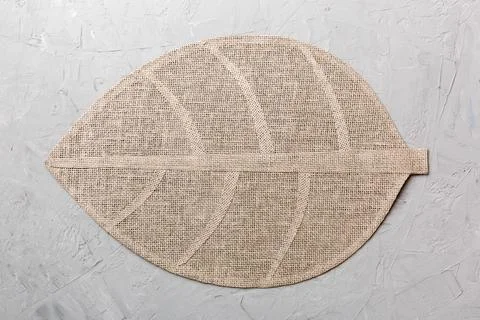 Perspective view of leaf shaped tablecloth for food on cement background. Emp Stock Photos