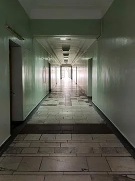 Perspective view of a long corridor at the end of which there is bright light Stock Photos