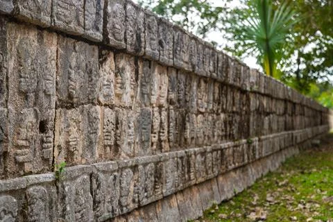 Perspective view of the long stone wall with carved skull reliefs on the Tzompan Stock Photos