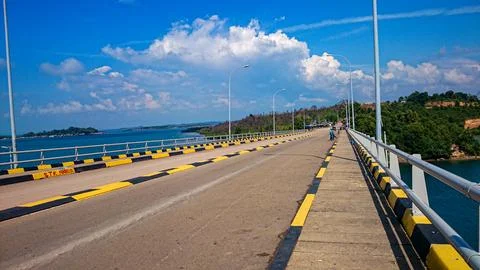 Perspective view of a modern bridge over the ocean with blue sky. 库存照片