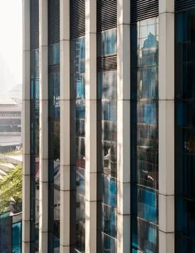 Perspective view of modern building facade with blue sky and clouds reflect.. Stock Photos