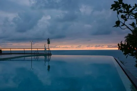Perspective view of an outdoor infinity swimming pool at sunset Stock Photos