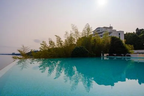 Perspective view of an outdoor infinity swimming pool at sunset Stock Photos