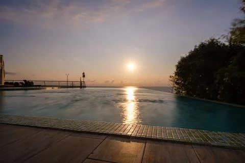 Perspective view of an outdoor infinity swimming pool at sunset Stock Photos