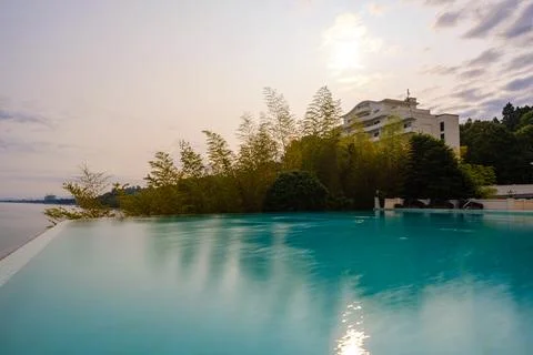 Perspective view of an outdoor infinity swimming pool at sunset Stock Photos