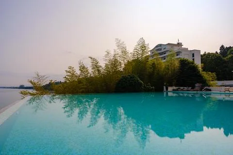 Perspective view of an outdoor infinity swimming pool at sunset Stock Photos