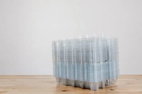 Perspective view of a pile of empty plastic egg boxes on a table Foto stock