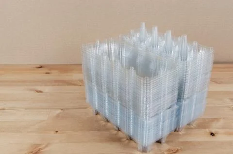 Perspective view of a pile of empty plastic egg boxes on a table Foto stock