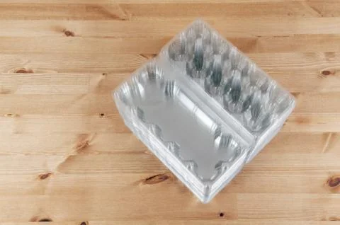 Perspective view of a pile of empty plastic egg boxes on a table Foto stock
