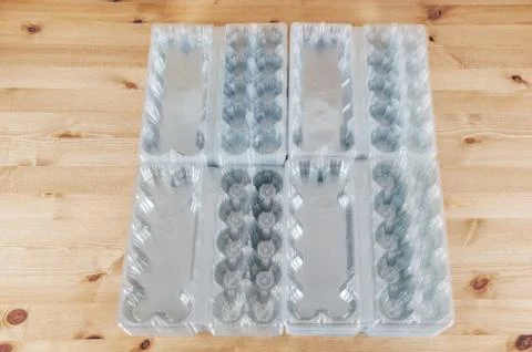 Perspective view of a pile of empty plastic egg boxes on a table Foto stock