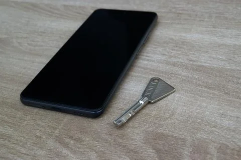 Perspective view of smartphone and security key on wood table Stock Photos